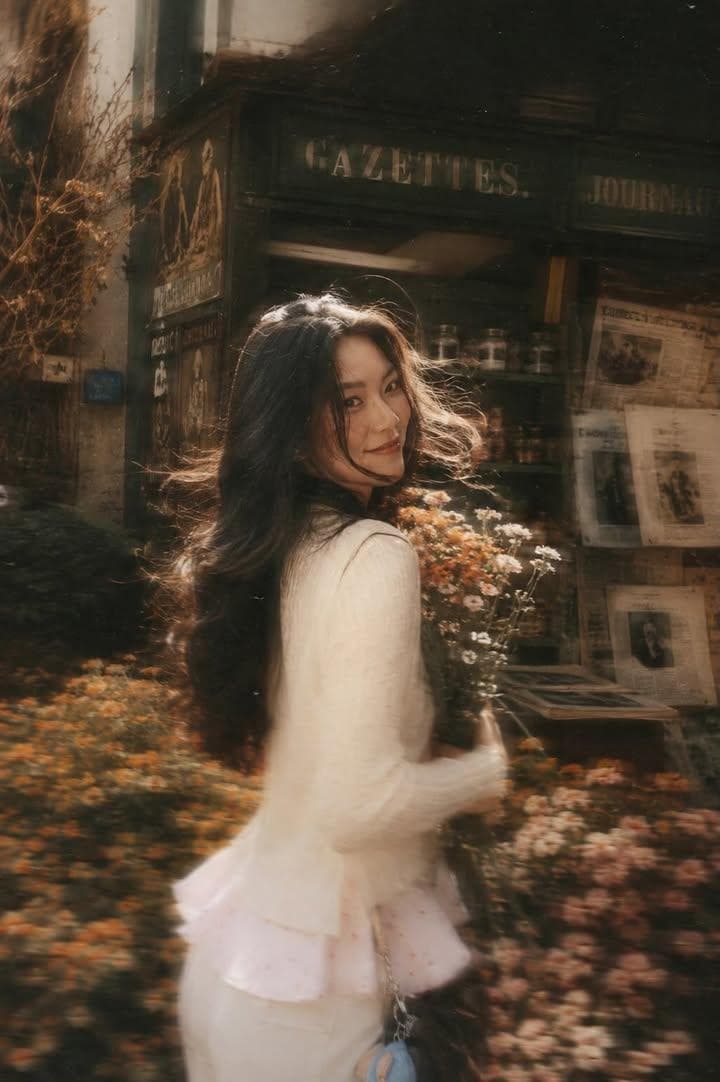 A beautiful young woman with long dark flowing hair holdi...