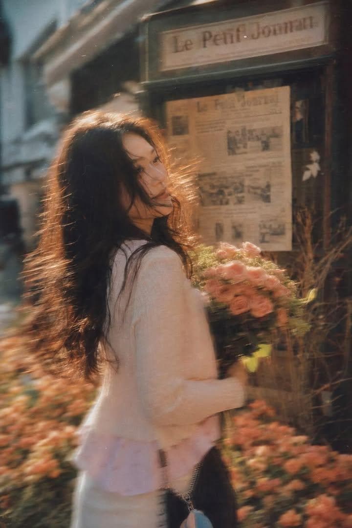 A beautiful young woman with long dark flowing hair holdi... 2